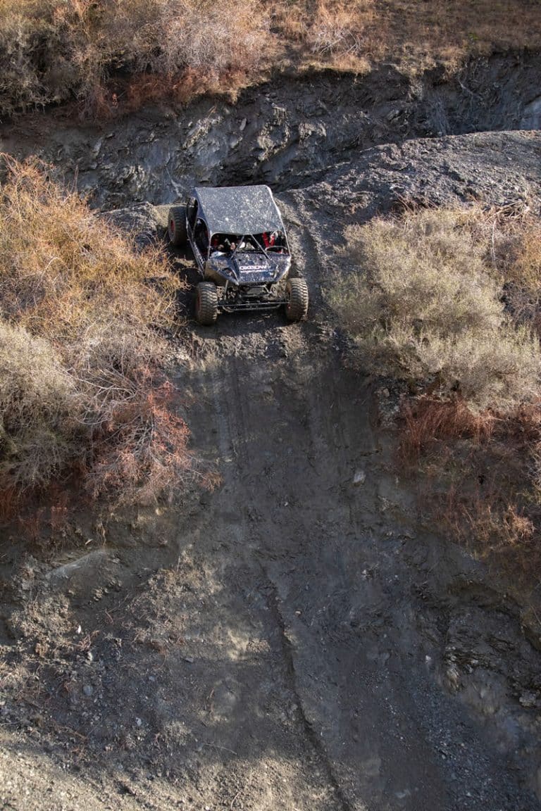 Off road vehicle in action just before driving down a steep piece of terrain